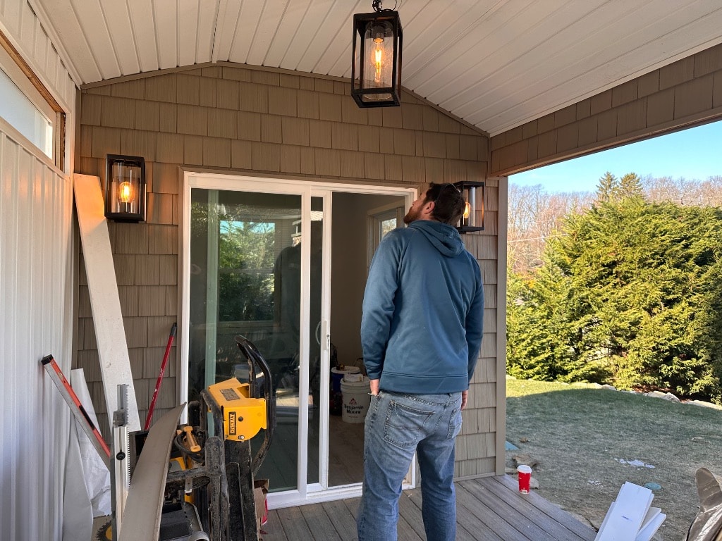 Murray Brothers finished porch entryway with shingle siding and lantern lighting