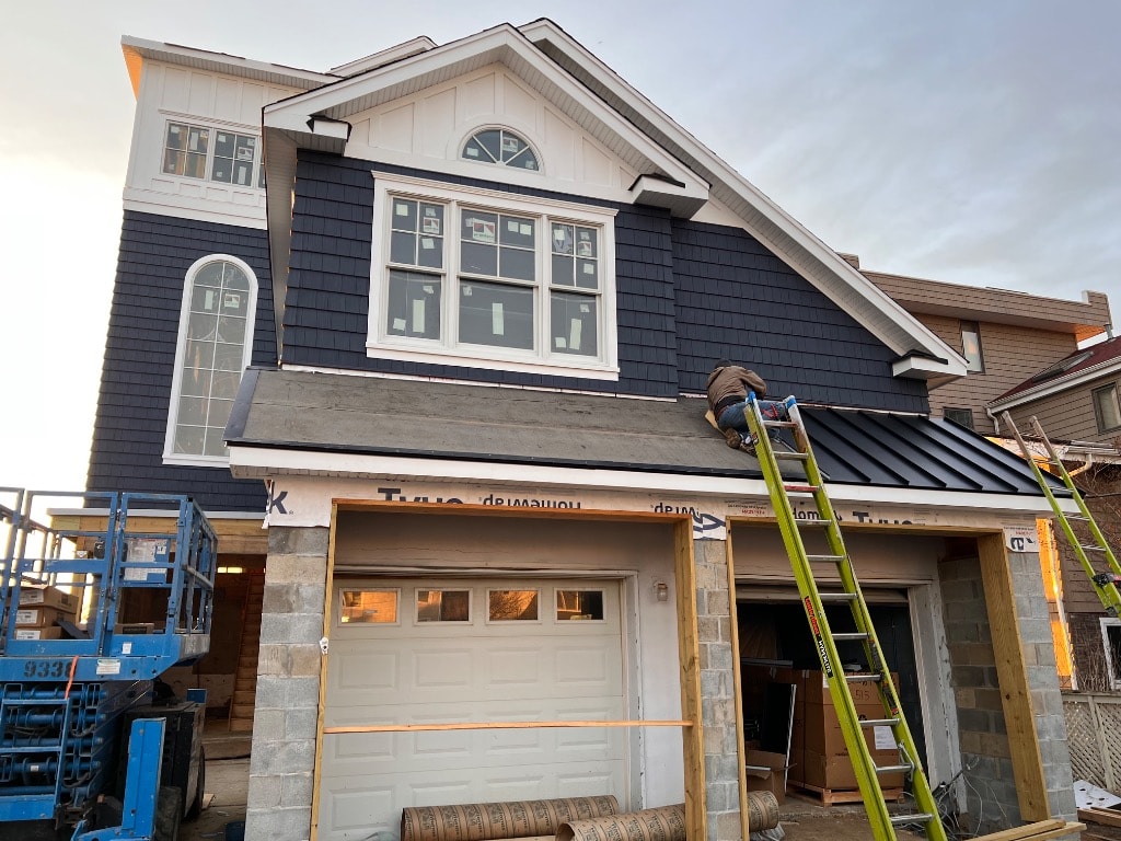 Murray Brothers crew member installing metal roofing and flashing on a new home